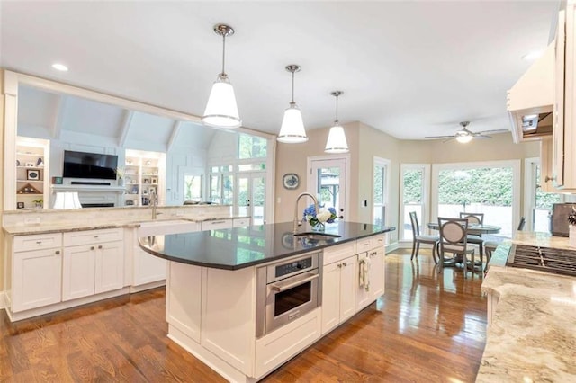 kitchen with appliances with stainless steel finishes, sink, pendant lighting, a healthy amount of sunlight, and dark hardwood / wood-style flooring