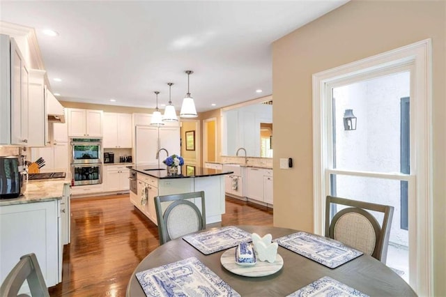 dining space with sink and hardwood / wood-style flooring