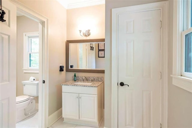 bathroom with tile patterned floors, vanity, crown molding, and toilet