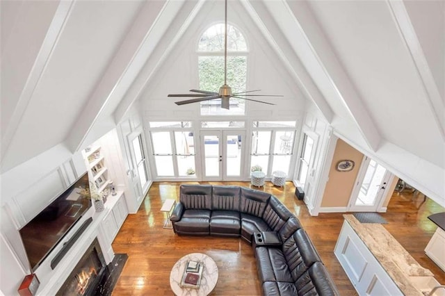 living room featuring ceiling fan, beamed ceiling, hardwood / wood-style floors, and high vaulted ceiling