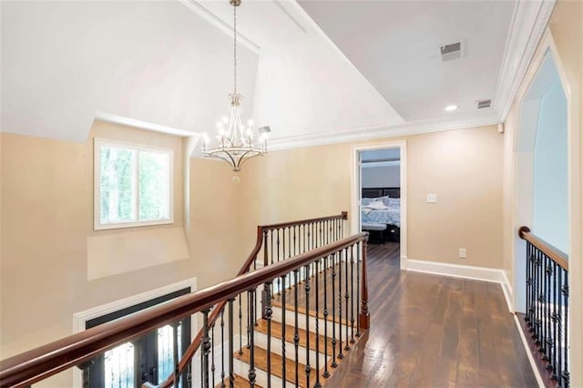 hall featuring dark hardwood / wood-style floors, a notable chandelier, and crown molding