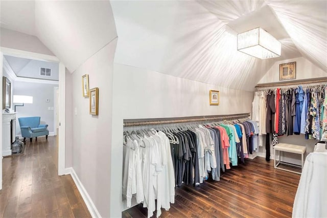 spacious closet featuring dark hardwood / wood-style flooring and vaulted ceiling