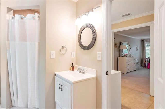 bathroom featuring tile patterned flooring, vanity, and ornamental molding