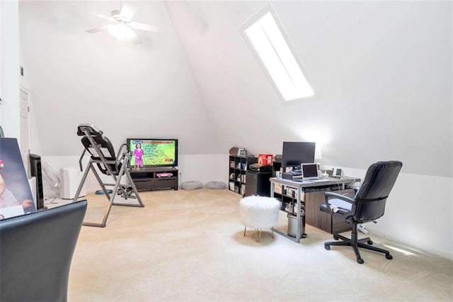 carpeted home office with vaulted ceiling with skylight and ceiling fan