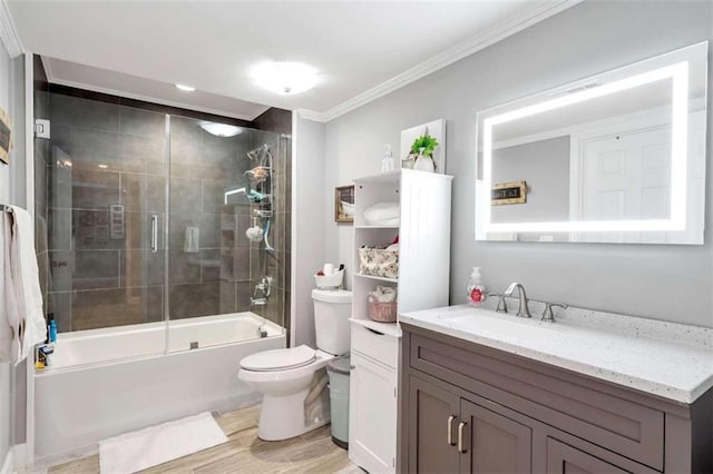 full bathroom with vanity, crown molding, hardwood / wood-style floors, shower / bath combination with glass door, and toilet