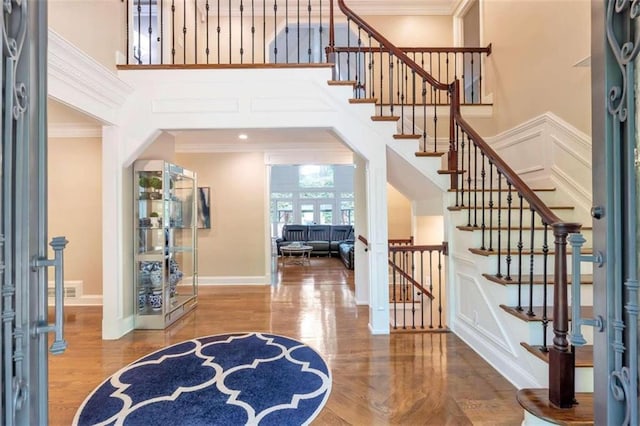 entryway featuring a high ceiling, crown molding, and hardwood / wood-style flooring