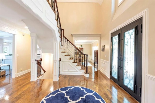 foyer with crown molding, french doors, hardwood / wood-style flooring, and a healthy amount of sunlight