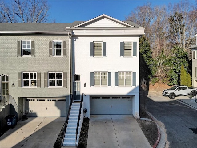 townhome / multi-family property with driveway, an attached garage, and brick siding