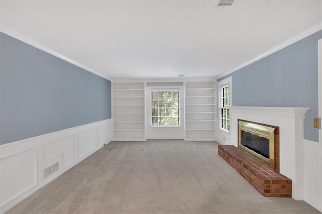 4181 Singing Post Ln NE, Roswell, GA 30075 - unfurnished living room with built in shelves, a wainscoted wall, crown molding, a brick fireplace, and carpet flooring