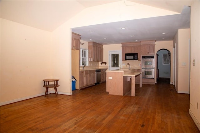 1398 Christmas Ln NE, Atlanta, GA 30329 - kitchen with stainless steel appliances, light countertops, arched walkways, dark wood finished floors, and a kitchen breakfast bar