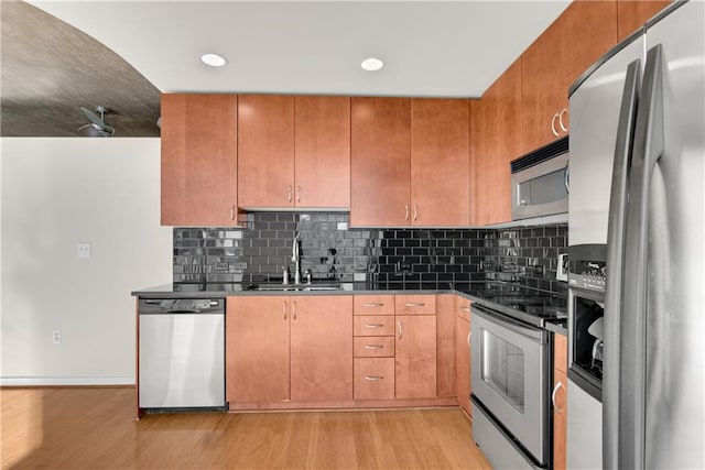 kitchen with stainless steel appliances, sink, and light wood-type flooring