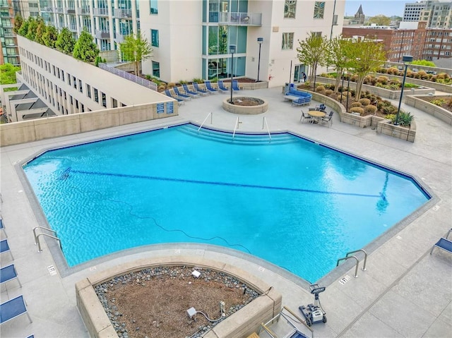 view of swimming pool with a patio and an outdoor fire pit