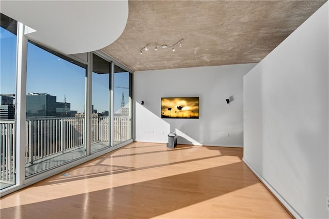 interior space with a wall of windows and light hardwood / wood-style floors