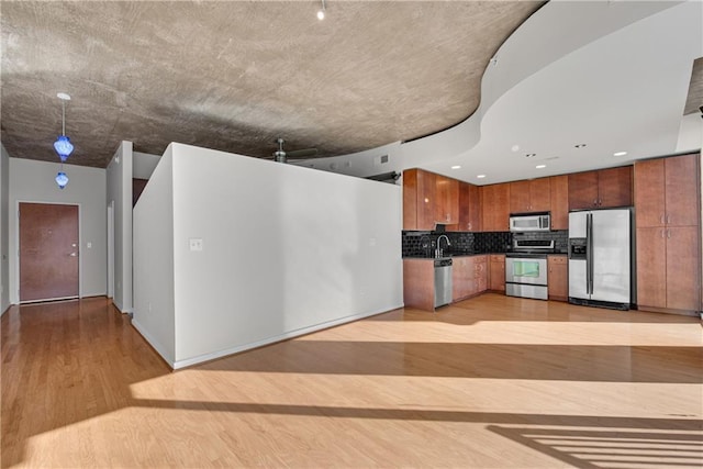 kitchen featuring stainless steel appliances, tasteful backsplash, and light hardwood / wood-style flooring