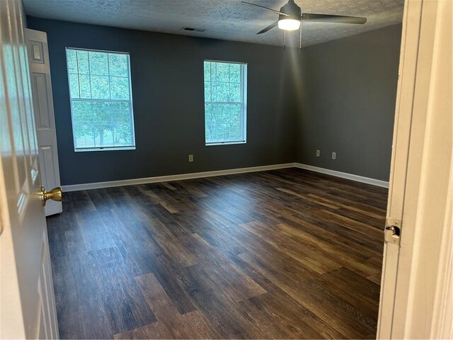 unfurnished room featuring dark wood-type flooring, ceiling fan, and a textured ceiling