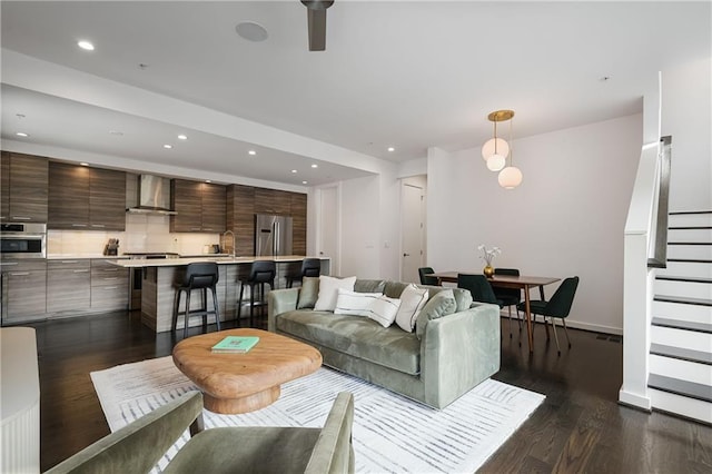 living room featuring stairway, recessed lighting, dark wood-style floors, and baseboards