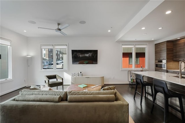 living room with dark wood finished floors, recessed lighting, and baseboards