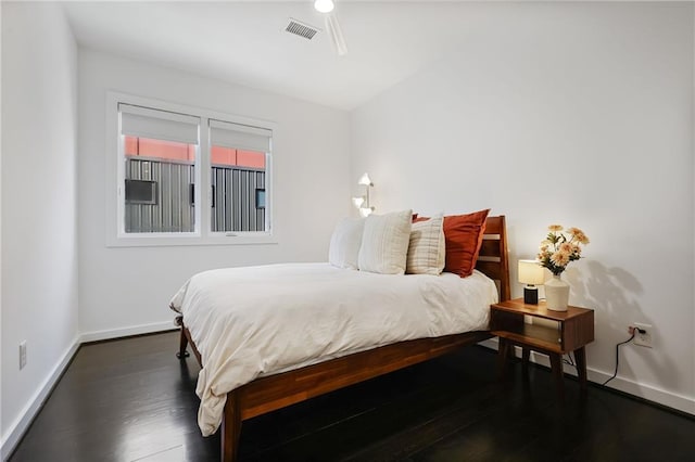 bedroom with dark wood finished floors, baseboards, and visible vents