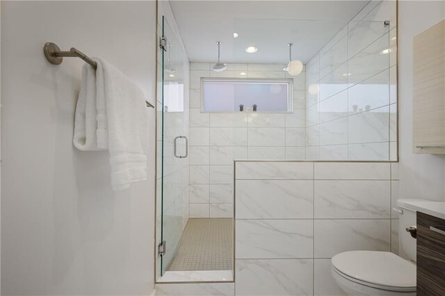 bathroom featuring walk in shower, vanity, toilet, and tile walls