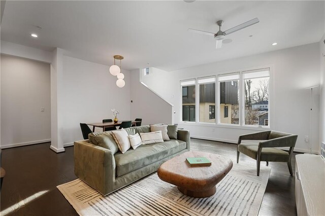 living room with dark hardwood / wood-style flooring and ceiling fan