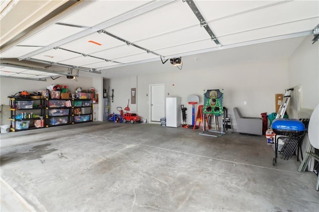 garage with a garage door opener and electric panel