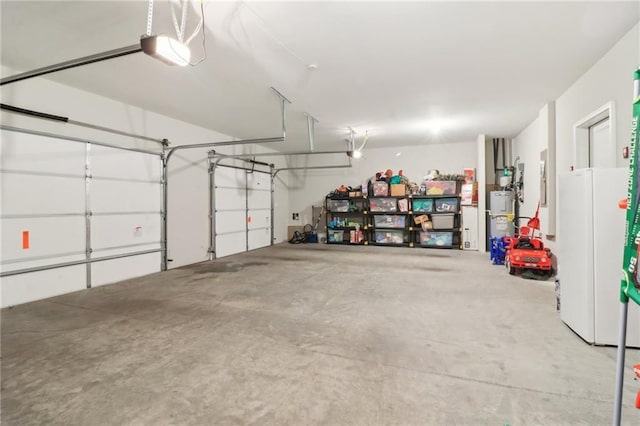 garage with white refrigerator, a garage door opener, and water heater