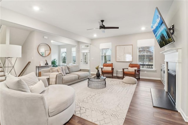 living room featuring dark hardwood / wood-style floors, a wealth of natural light, and ceiling fan