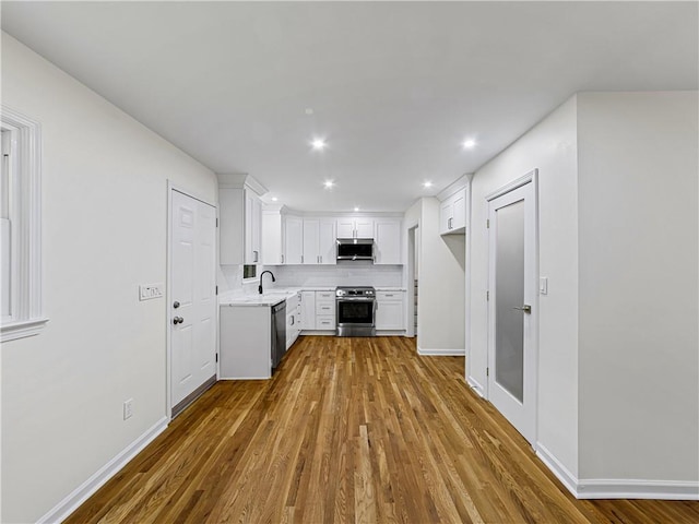 466 Thackery Pl SW, Atlanta, GA 30311 - kitchen with stainless steel appliances, a sink, dark wood-style flooring, light countertops, and white cabinets