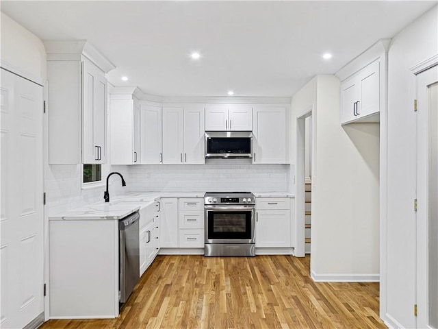 466 Thackery Pl SW, Atlanta, GA 30311 - kitchen featuring stainless steel appliances, tasteful backsplash, light wood-style floors, white cabinetry, and recessed lighting