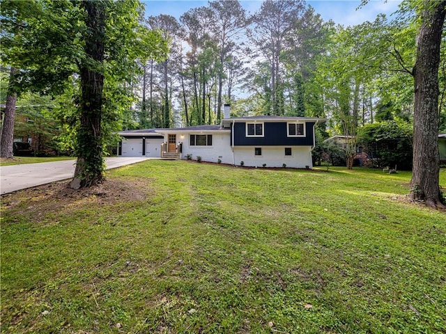 466 Thackery Pl SW, Atlanta, GA 30311 - split level home featuring concrete driveway, a front lawn, a chimney, a garage, and view of wooded area