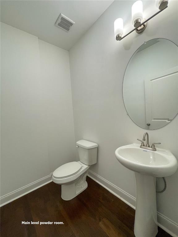 bathroom with toilet, sink, and hardwood / wood-style floors