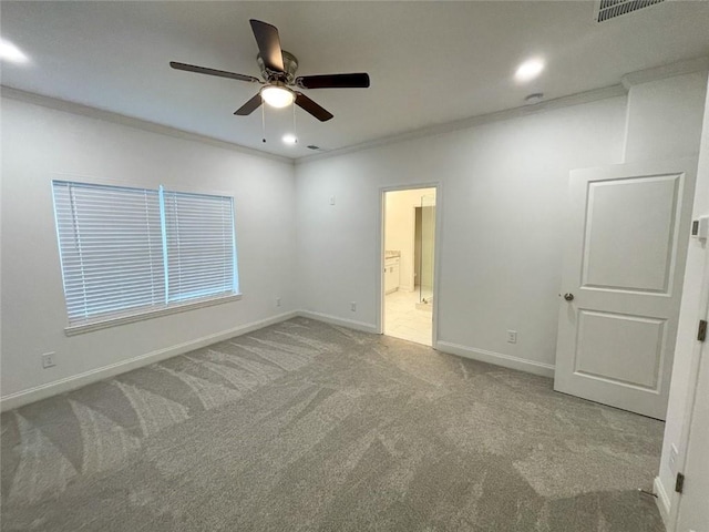 carpeted empty room featuring ceiling fan and crown molding