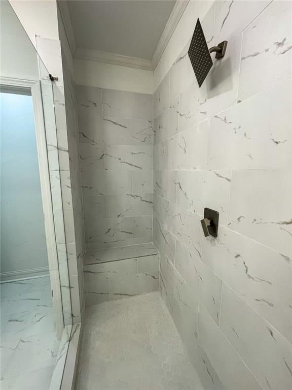 bathroom with a tile shower and ornamental molding