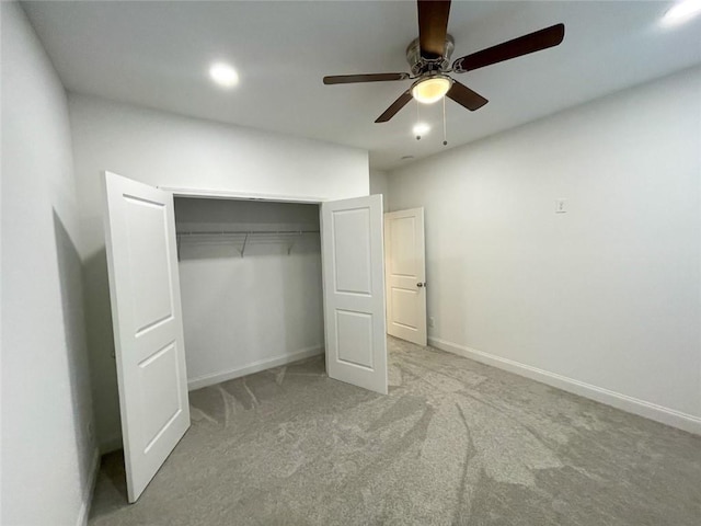 unfurnished bedroom featuring ceiling fan, light colored carpet, and a closet