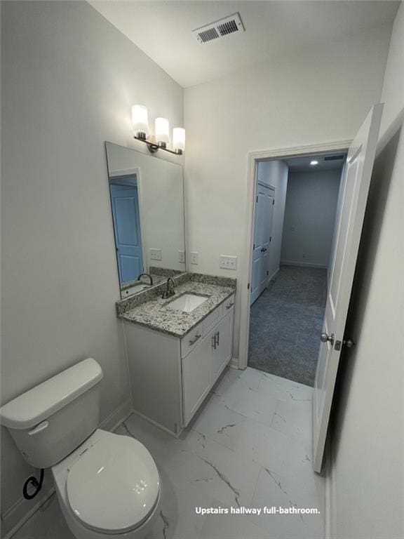 bathroom featuring toilet and vanity