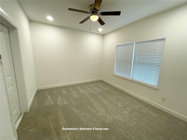 carpeted spare room featuring ceiling fan