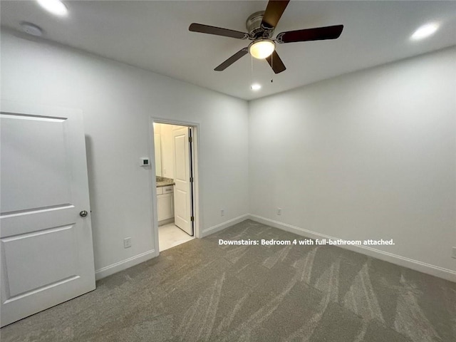 unfurnished bedroom with ensuite bathroom, light colored carpet, and ceiling fan