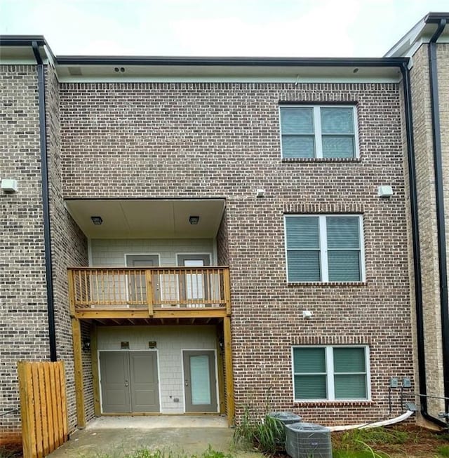 rear view of house featuring a balcony and a garage