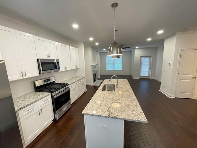 kitchen featuring appliances with stainless steel finishes, an island with sink, white cabinets, and sink