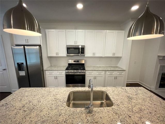 kitchen featuring sink, stainless steel appliances, white cabinetry, and light stone countertops