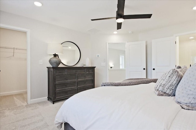 bedroom featuring ceiling fan, light colored carpet, baseboards, a spacious closet, and recessed lighting