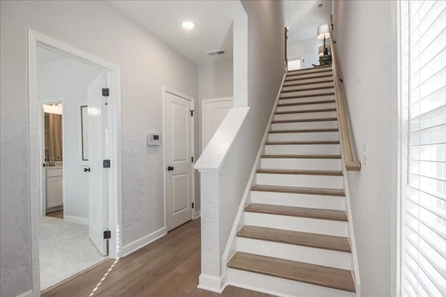 staircase featuring visible vents, recessed lighting, baseboards, and wood finished floors