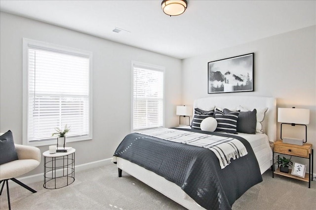 carpeted bedroom featuring baseboards and visible vents