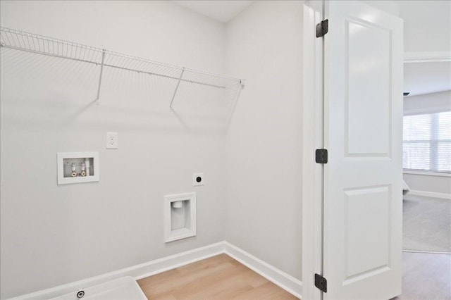 laundry area featuring laundry area, light wood finished floors, hookup for a washing machine, baseboards, and hookup for an electric dryer