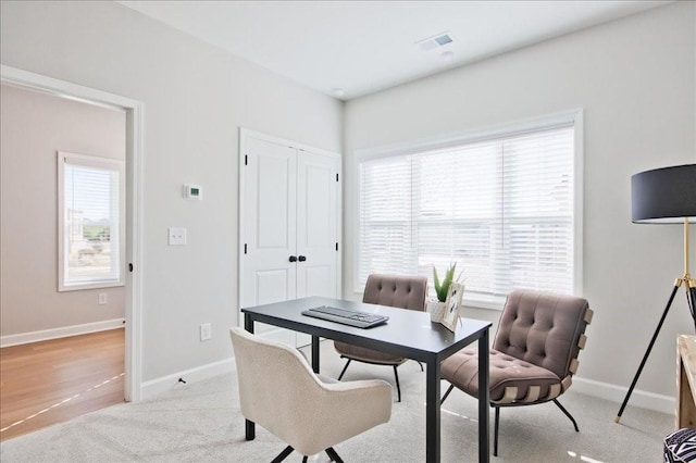 home office with baseboards, light colored carpet, and visible vents