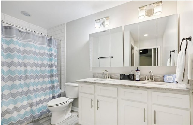 bathroom with double vanity, toilet, a shower with shower curtain, and a sink