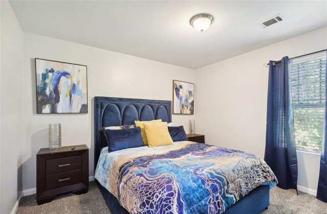 bedroom featuring visible vents, carpet flooring, and baseboards