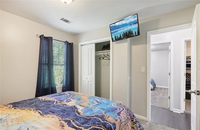 carpeted bedroom featuring visible vents, baseboards, and a closet