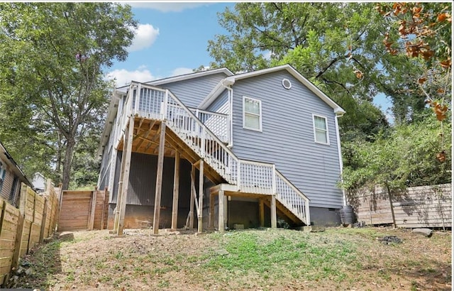 rear view of house with fence, stairway, and a deck