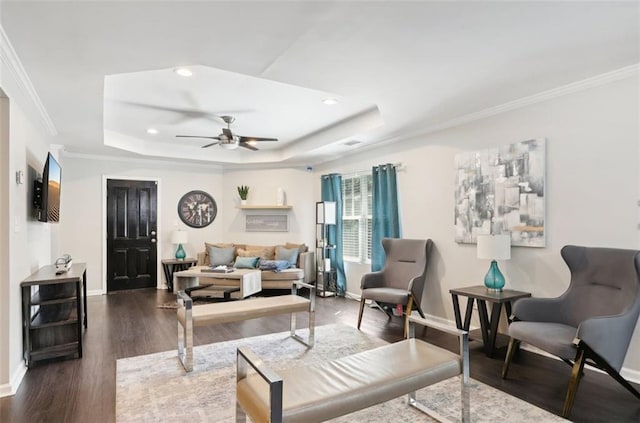 living room with recessed lighting, ceiling fan, a tray ceiling, dark wood-type flooring, and baseboards